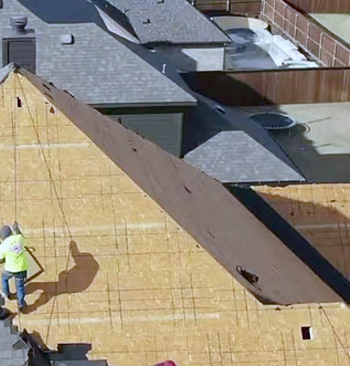 A finished dark-shingled roof on a large north Texas home, photographed from above