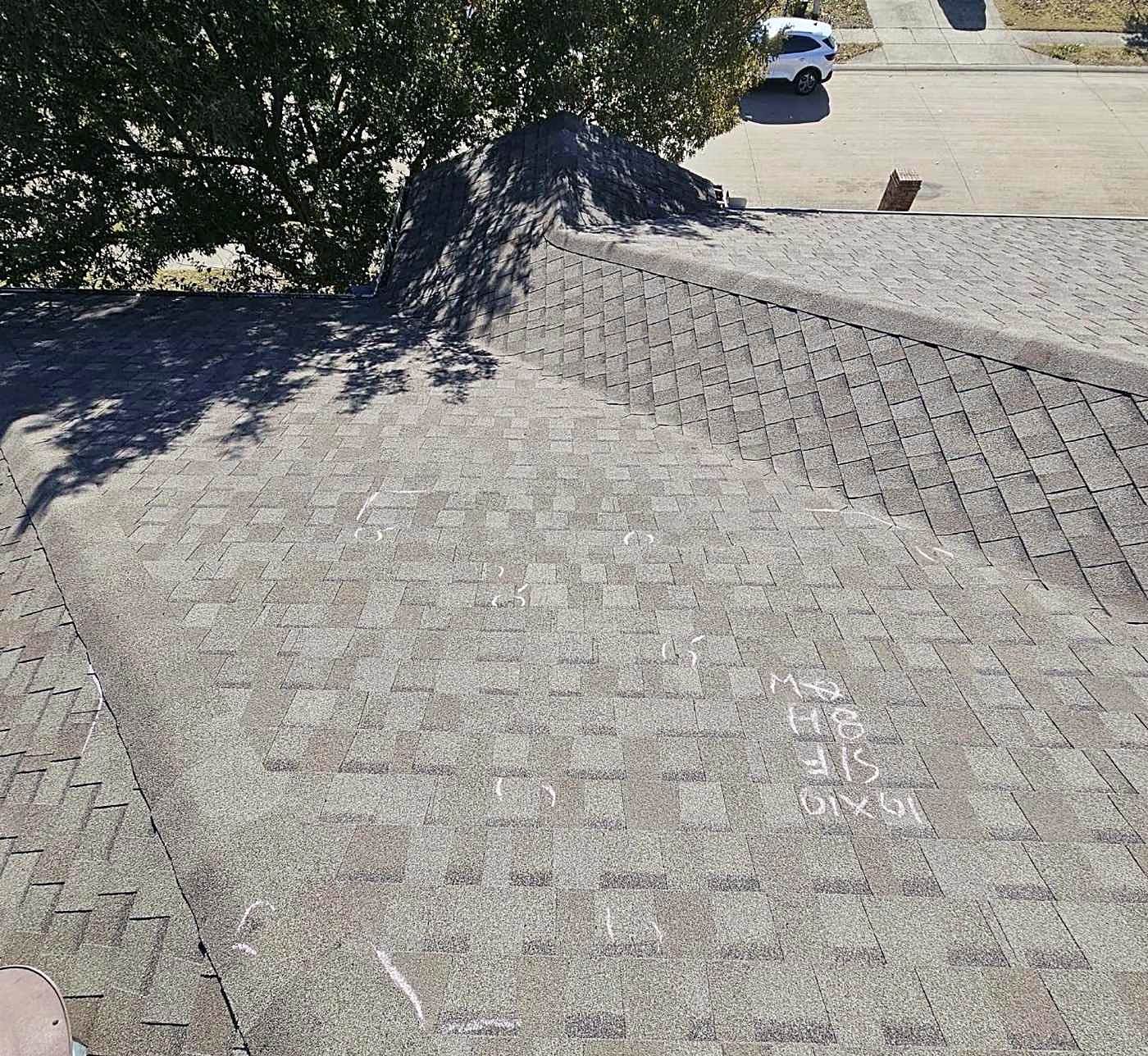 A finished dark-shingled roof on a large north Texas home, photographed from above