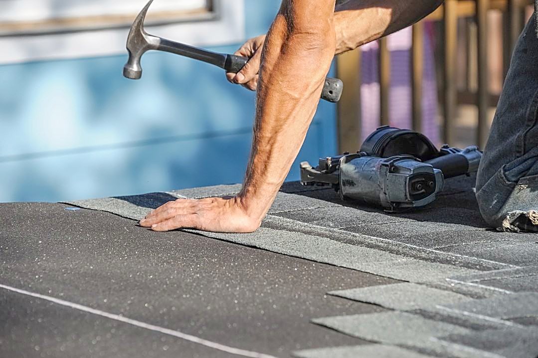 A roofer in high-visibility clothing working across freshly laid roof decking