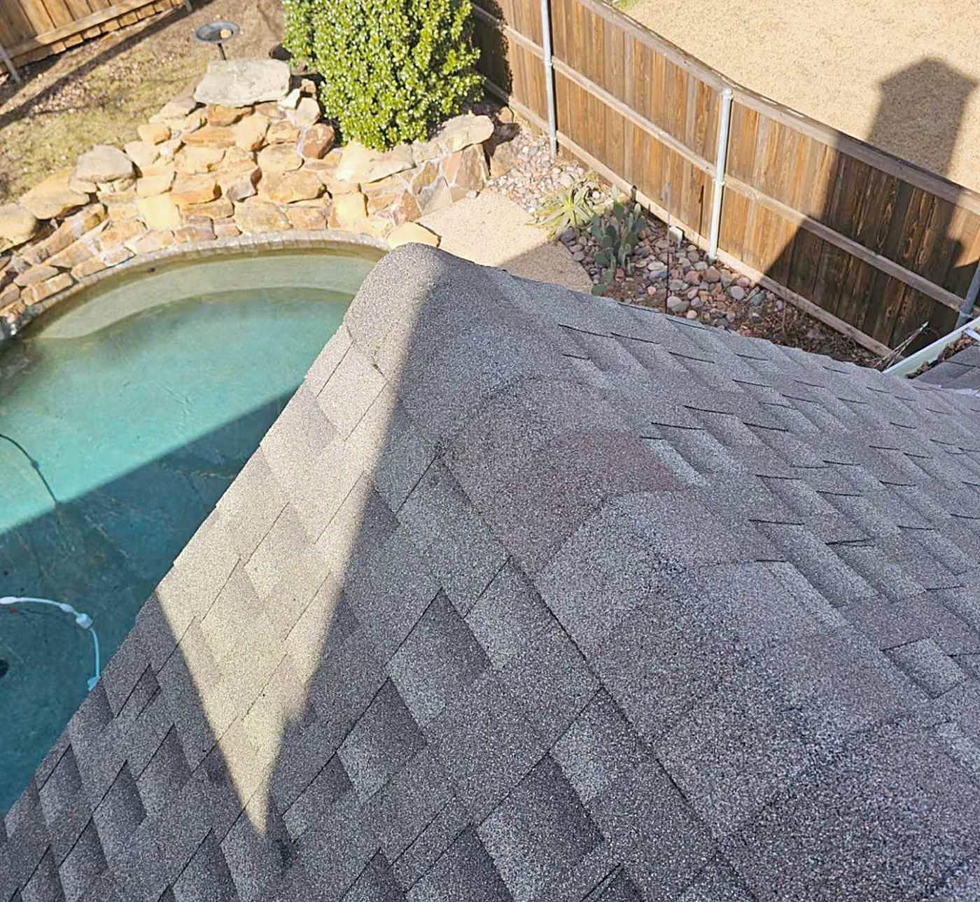 Chalk marks circling hail strikes on a weathered shingle roof